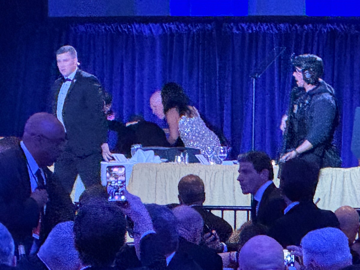 U.S. Secret Service agents surround President Donald Trump as he is taken from the stage after a shooting incident outside the ballroom during the White House Correspondents Dinner, Saturday, April 25 ...