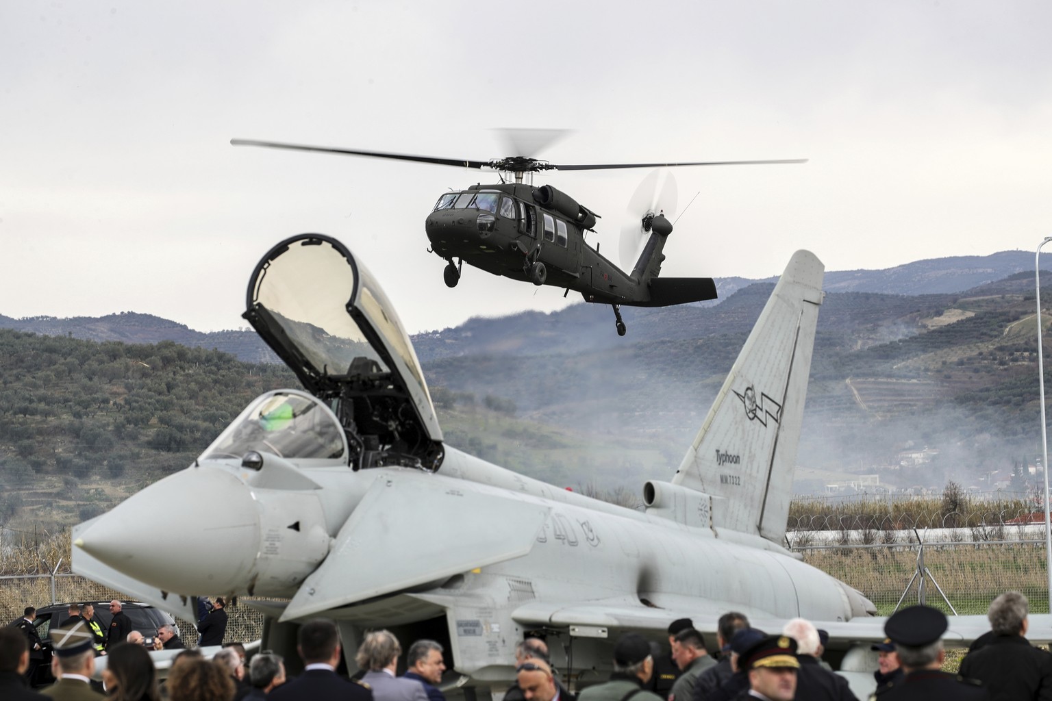 A military helicopter lands near an Italian Eurofighter at an airbase during a ceremony, in Kocuve, about 85 kilometers (52 miles) south of Tirana, Albania, Monday, March 4, 2024. NATO member Albania ...