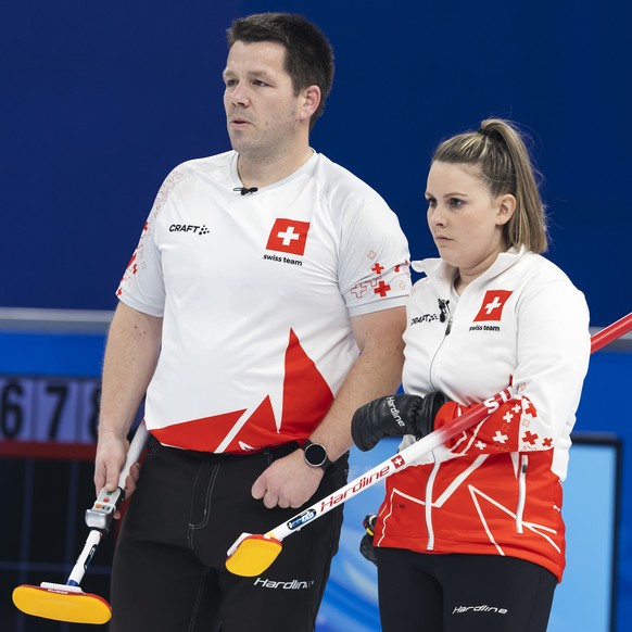 Martin Rios, left, and Jenny Perret of Switzerland team observe during the curling mixed doubles preliminary round game between Czech Republic and Switzerland at the 2022 Olympic Winter Games in Beiji ...