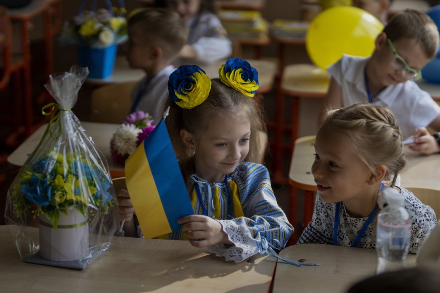 Taisia �??�??Shcherba, 6, left, speaks with her classmate during their first day of school at a public school in Irpin, Ukraine, Thursday, Sept. 1, 2022. Ukrainian children return to school without sh ...