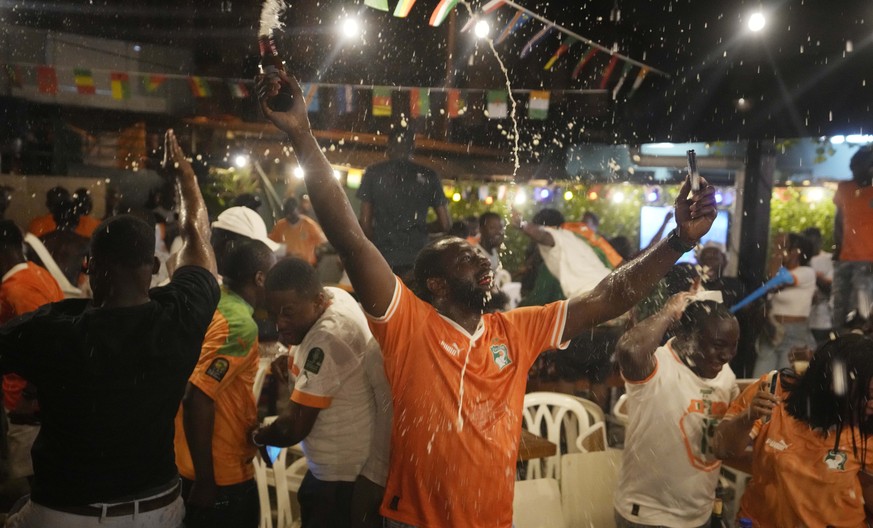 Ivory Coast soccer fans celebrate at a viewing center in Abidjan, Ivory Coast after Ivory Coast soccer team defeated Senegal in a penalty shootout during their African Cup of Nations round of 16 socce ...