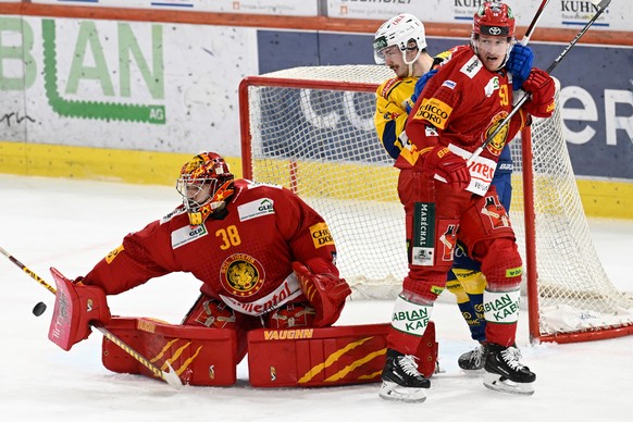 Tigers Goalie Stephane Charlin, links, und Juuso Riikola, rechts, im Kampf um den Puck gegen Davos Yannick Frehner, Mitte, beim Eishockey-Qualifikationsspiel der National League zwischen den SCL Tiger ...