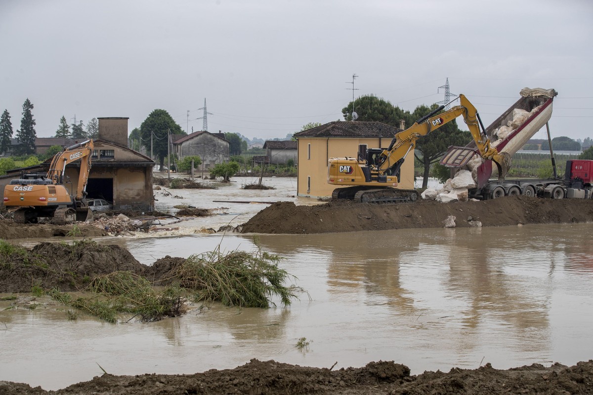 epa10641405 An excavator tries to rebuild embankment of the Sillaro river after it broke the embankment, destroying a house and flooded the town in attempt to block the water that is flooding the surr ...
