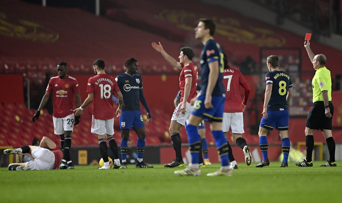 Referee Mike Dean, right, shows a red card to Southampton's Alex Jankewitz, fourth left, during the English Premier League soccer match between Manchester United and Southampton, at the Old Traff ...