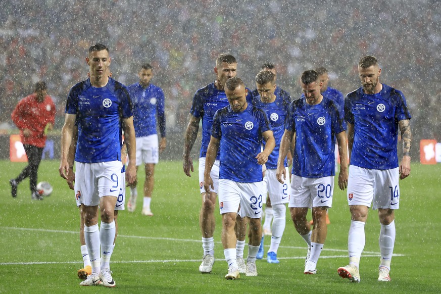 Slovakia players walk under heavy rain during warmup before the Euro 2024 group J qualifying soccer match between Portugal and Slovakia at the Dragao stadium in Porto, Portugal, Friday, Oct. 13, 2023. ...