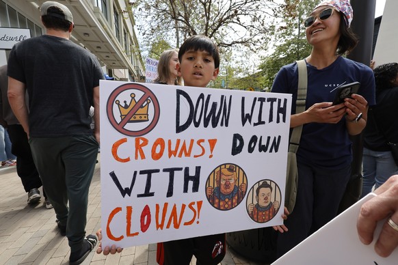 epa12012645 Protesters rally during a nationwide ?Hands Off!? protest against President Trump, his advisor Elon Musk and his policies in front of a Tesla showroom at the Broadway Plaza Mall in Walnut ...
