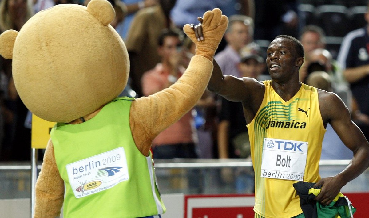 epa01826182 Usain Bolt of Jamaica gives high 5 to the mascot "Berlino" after winning the 100m final at the 12th IAAF World Championships in Athletics, Berlin, Germany, 16 August 2009. EPA/KA ...