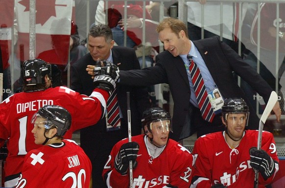 Swiss head coach, Canadian-German Ralph Krueger, right, congratulates his forward Paul di Pietro, left, who just scored his first of two goals, next to assistant coach Canadian Peter John Lee, center, ...