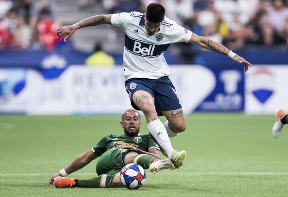Portland Timbers&#039; Bill Tuiloma, back, falls as he tries to stop Vancouver Whitecaps&#039; Joaquin Ardaiz during the second half of an MLS soccer match Friday, May 10, 2019, in Vancouver, British  ...