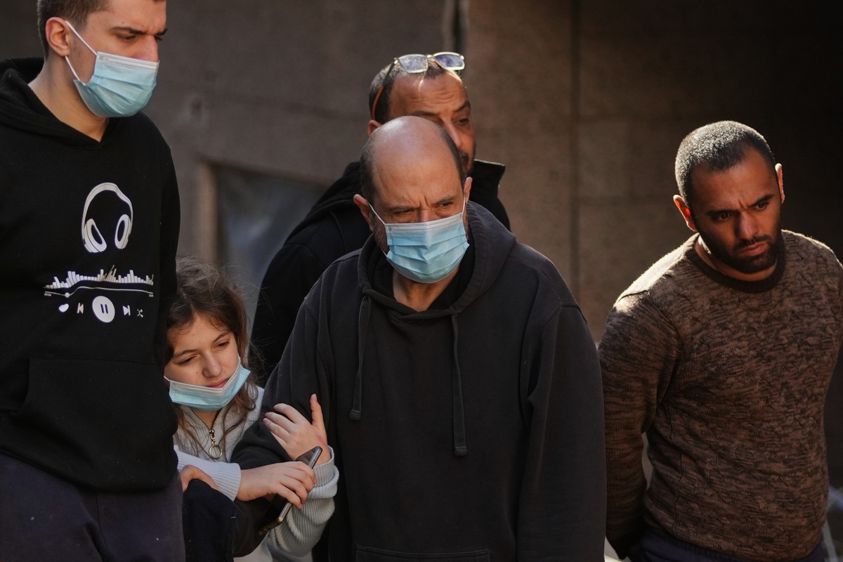 Residents Omar Amouri, center, and his daughter Lara, left, look on at the site of a building where efforts continue to recover the body of missing woman Zahraa Aboud, 26, after it was destroyed in an ...