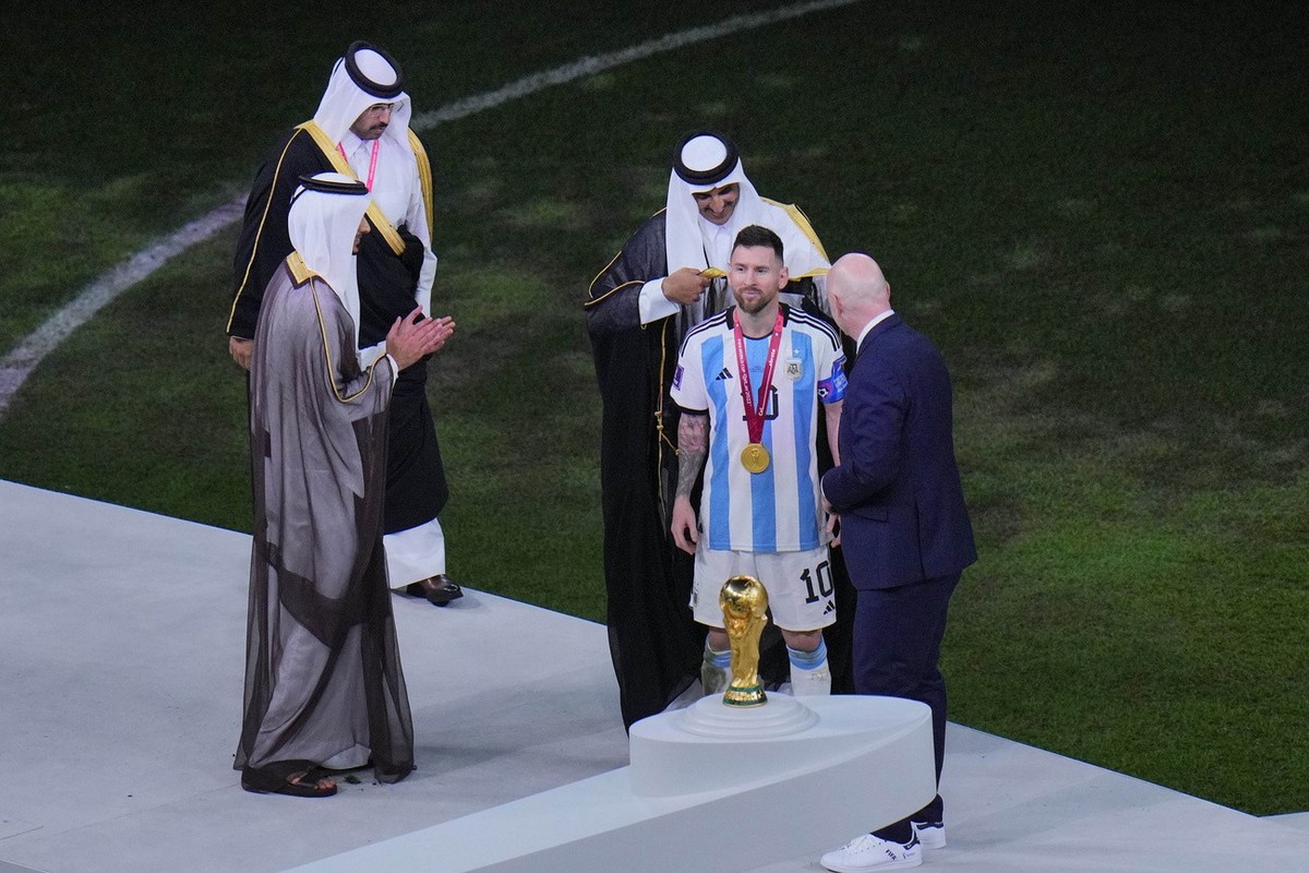 The Emir of Qatar Sheikh Tamim bin Hamad Al Thani puts on a cloak on Argentina's Lionel Messi after he won the World Cup final soccer match between Argentina and France at the Lusail Stadium in L ...