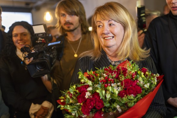Leader of the Social Democratic Party Vilija Blinkeviciute, center, smiles as she waits for the results of the second round of Lithuania&#039;s parliamentary election, in an office in Vilnius, Lithuan ...