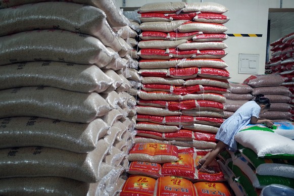 epaselect epa07758726 A Chinese girl stands beside bags of soybeans at a grain wholesale market in Beijing, China, 06 August 2019. The Chinese government announced on 06 August that it has suspended p ...