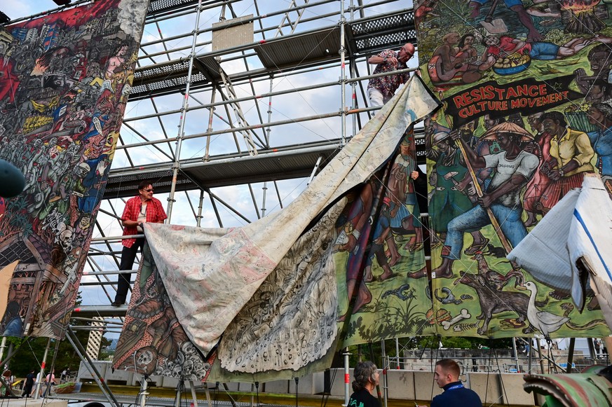 21.06.2022, Hessen, Kassel: Documenta-Mitarbeiter bauen das umstrittene Gro�banner �People&#039;s Justice� des indonesischen K�nstlerkollektivs Taring Padi auf dem Friedrichsplatz ab. (zu dpa &quot;do ...