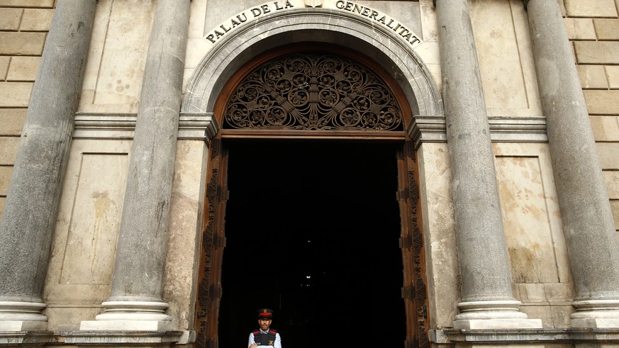 A Catalan police officer stands guard at the entrance of the Palau Generalitat in Barcelona, Spain, Monday Oct. 30, 2017. Catalonia&#039;s civil servants face their first full work week since Spain&#0 ...