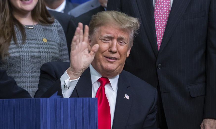 epa07242837 US President Donald J. Trump reacts after signing the Agriculture Improvement Act of 2018 farm bill in the South Court Auditorium of the Eisenhower Executive Office Building on the White H ...