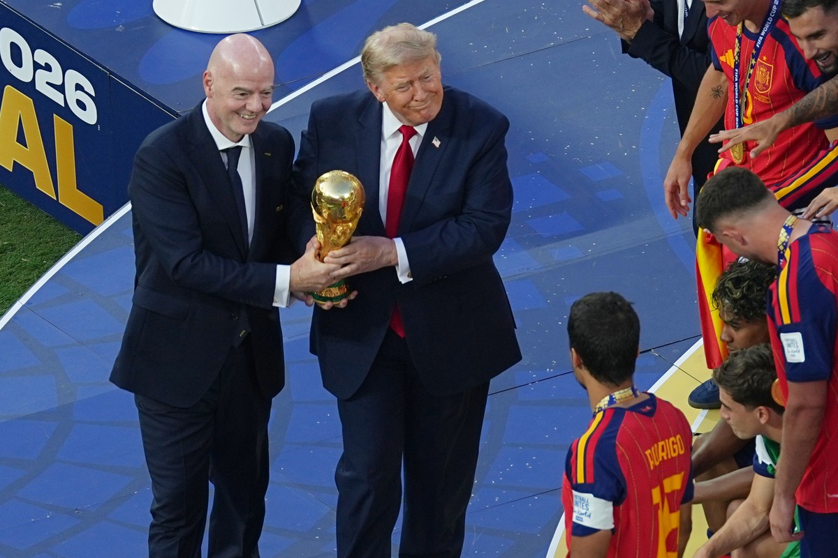 FIFA President Gianni Infantino and President Donald J. Trump present the trophy to Spain's Rodri (16) after the World Cup final soccer match between Spain and Argentina in East Rutherford, N.J., ...