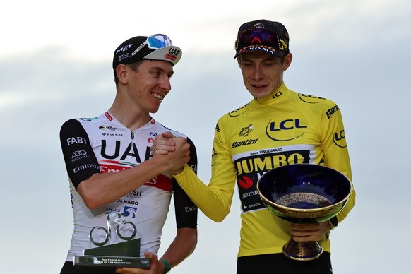 epa10764825 Second placed Slovenian rider Tadej Pogacar (L) of UAE Team Emirates and winner Danish rider Jonas Vingegaard of Jumbo Visma celebrate on the podium after the 21st and final stage of the T ...