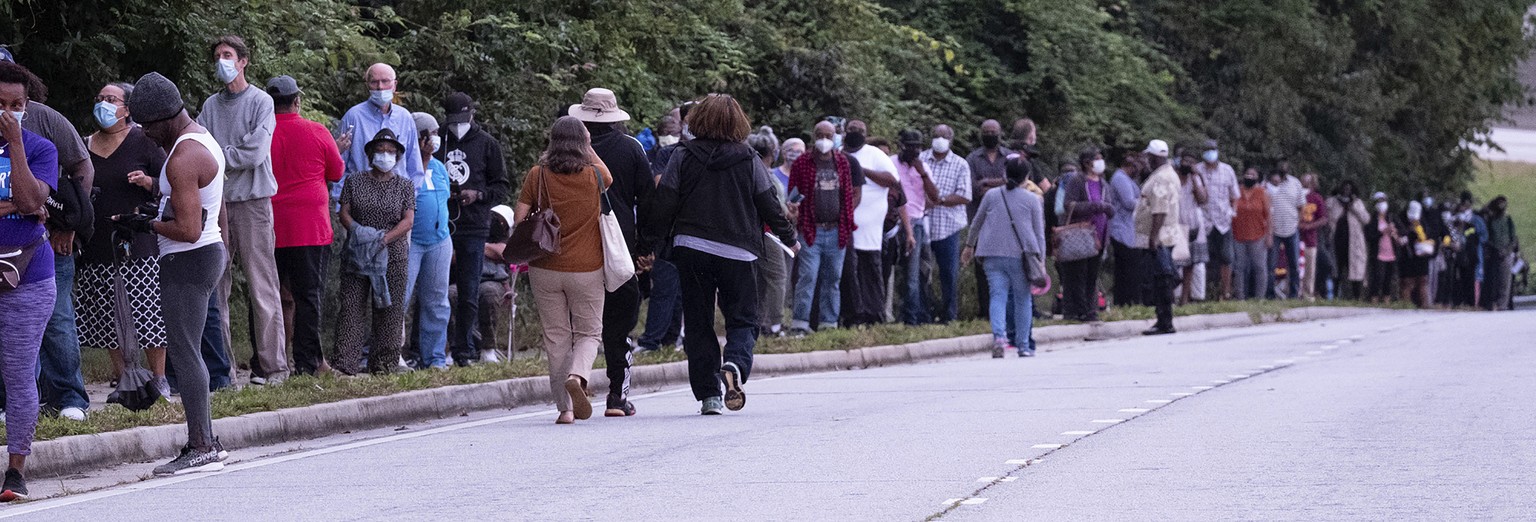 People wait in line to vote in Decatur, Ga., Monday, Oct. 12, 2020. (Ben Gray/Atlanta Journal-Constitution via AP)