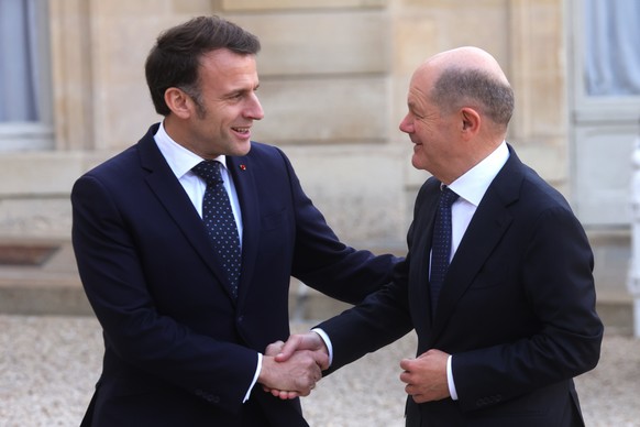 epa11902958 French President Emmanuel Macron (L) welcomes German Chancellor Olaf Scholz (R) ahead of a meeting on war in Ukraine and European security at the Elysee Palace in Paris, France, 17 Februar ...