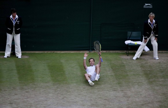 Richard Gasquet of France falls to the floor after winning his match against Stan Wawrinka of Switzerland at the Wimbledon Tennis Championships in London, July 8, 2015. REUTERS/Stefan Wermuth