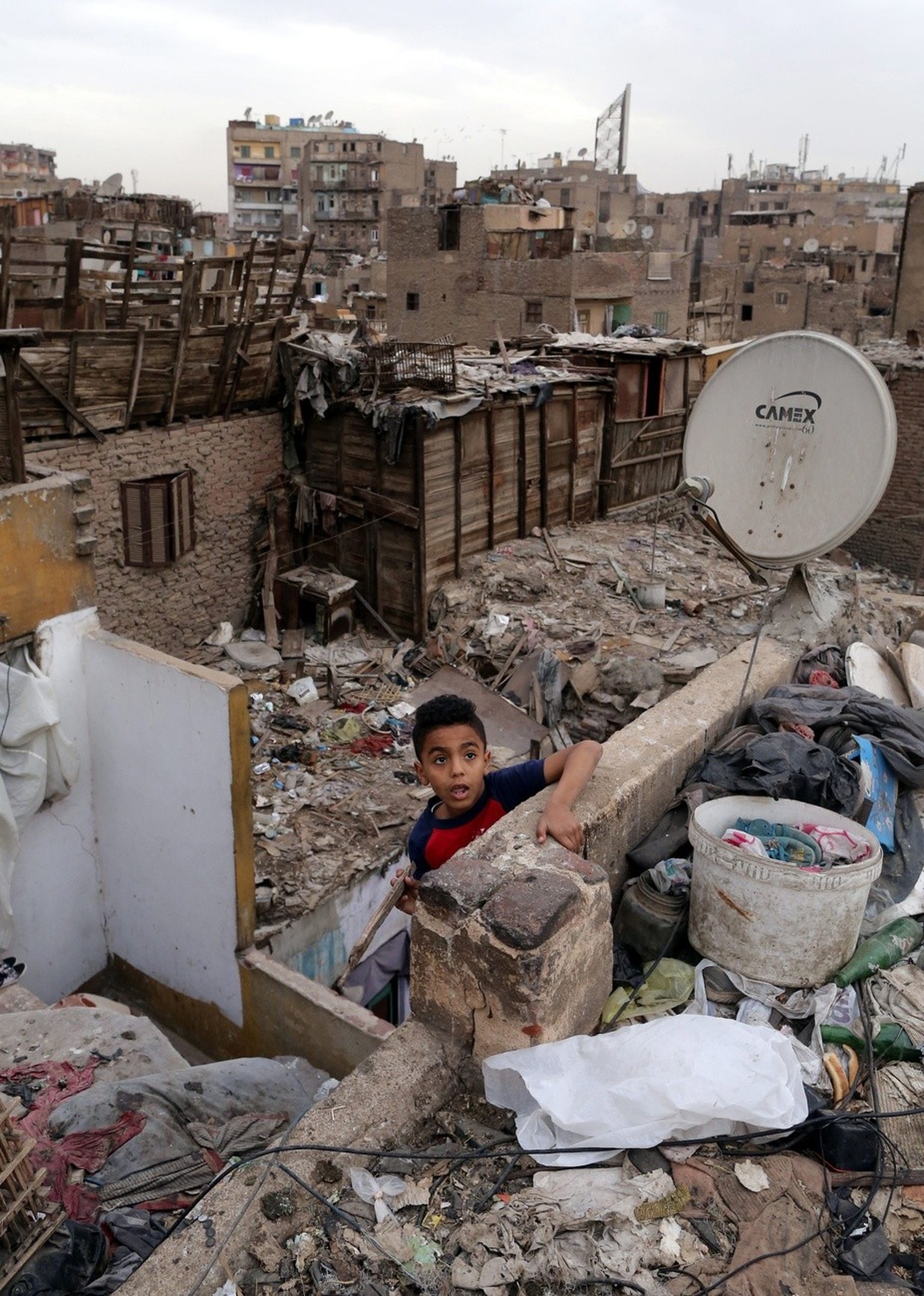 epa04678846 An Egyptian boy plays on the roof of a home at the Bulaq slum in Cairo, Egypt, 25 March 2015. According to estimates, about 16 million Egyptians live in slum neighborhoods lacking basic fa ...