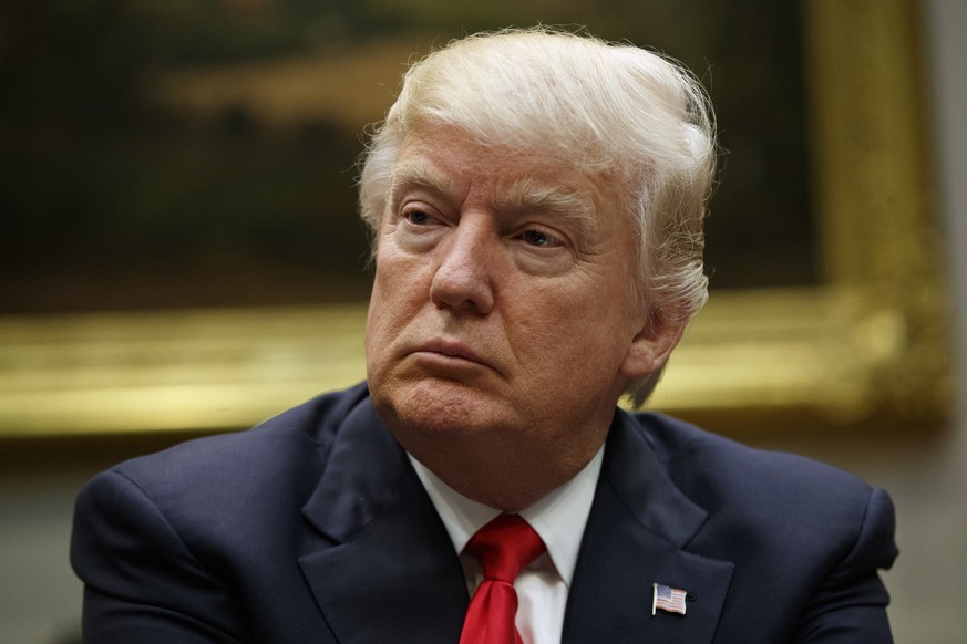 In this March 31, 2017, photo, President Donald Trump listens during a meeting with the National Association of Manufacturers in the Roosevelt Room of the White House in Washington. Slim majorities of ...