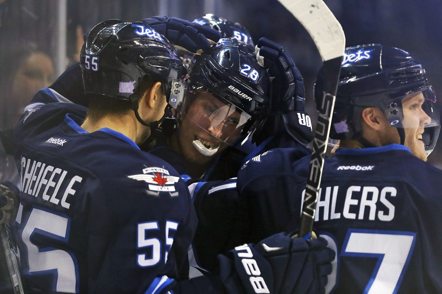 Winnipeg Jets&#039; Patrik Laine (29) celebrates his third goal of the night with Mark Scheifele (55) and Nikolaj Ehlers (27) during the second period of an NHL hockey game against the Dallas Stars, T ...