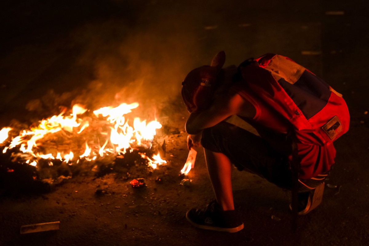 epaselect epa07541629 Supporters of the Venezuelan opposition burn Venezuelan currency at a demonstration against President Maduro's Government, in the streets of Caracas, Venezuela, 01 May 2019. ...