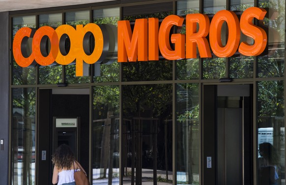 Le logo de la Coop et le logo de la Migros sont photographies cote a cote sur un batiment commercial commun ce mardi 23 aout 2016 sur la place de la Sallaz a Lausanne. (KEYSTONE/Jean-Christophe Bott)
