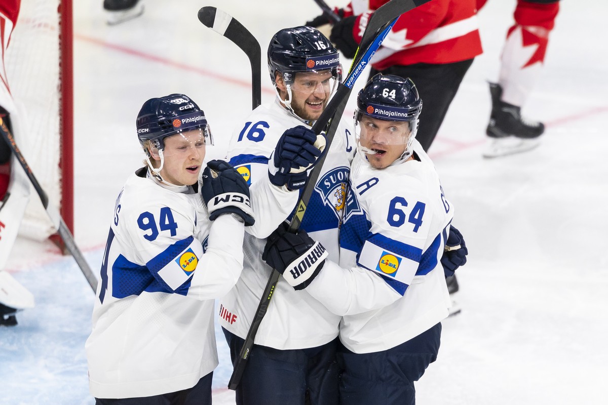epa13005536 Finland's Aleksander Barkov, center, celebrates his 2-2 goal with Finland's Konsta Helenius, left, and Finland's Mikael Granlund, right, during the 2026 IIHF Men's Ice  ...