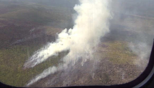 This undated image taken from a video provided on Wednesday, Aug. 8, 2019, by Russian Emergency Situations Ministry Press Service shows a forest fire seen from a window of a jet as it prepares to spra ...