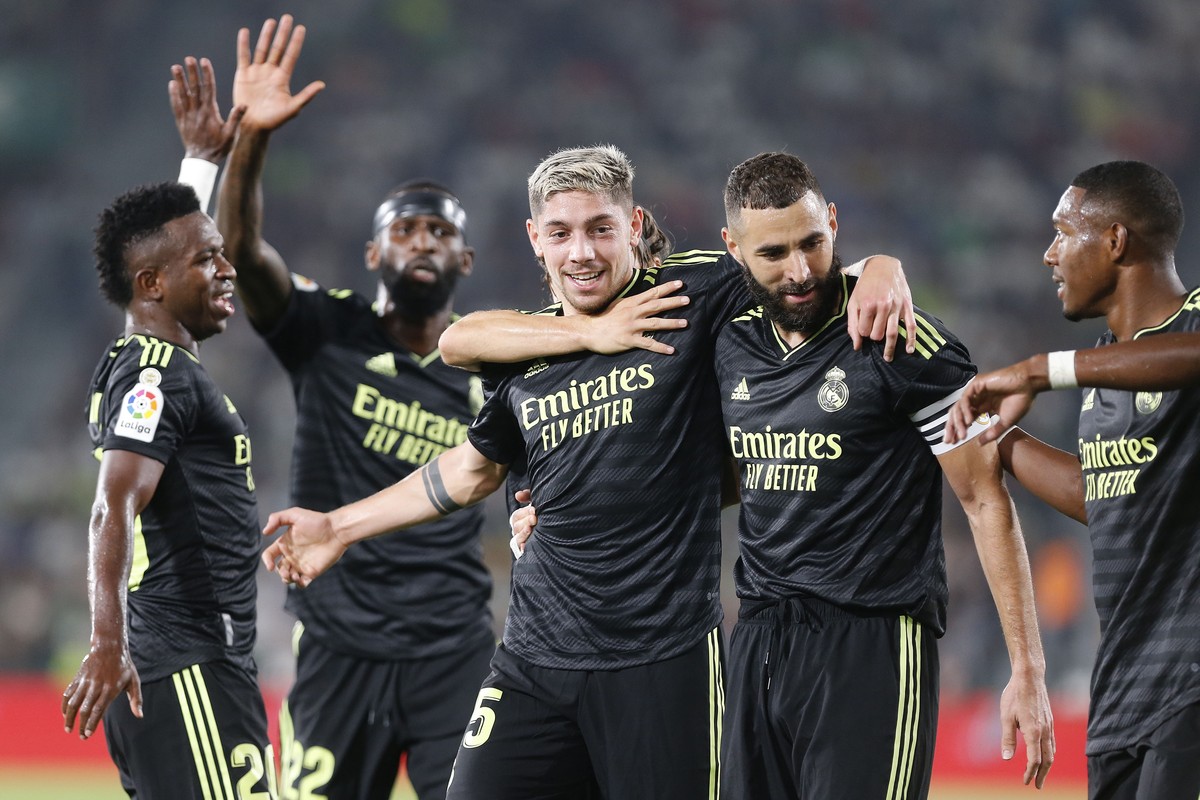 epa10253449 Real Madrid's Federico Valverde (C) celebrates with teammate Karim Benzema (2-R) after scoring the 1-0 lead during the Spanish LaLiga soccer match between Elche CF and Real Madrid in  ...
