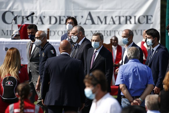 Italian Premier Mario Draghi, center, arrives to attend a ceremony commemorating the victims of the 2016 earthquake in Amatrice, central Italy, Tuesday, Aug. 24, 2021. Over 290 people lost their lives ...