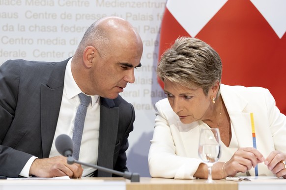 Bundespraesident Alain Berset, links, diskutiert mit Bundesraetin Karin Keller-Sutter waehrend einer Medienkonferenz des Bundesrates zu den Resultaten der eidgenoessischen Abstimmungen, am Sonntag, 18 ...