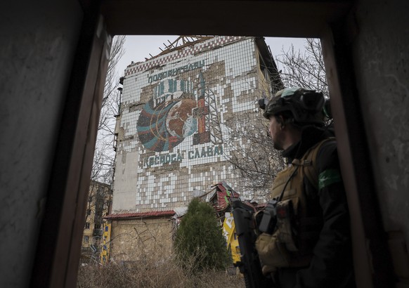 epa12608376 A handout picture made available by the press service of the 24th Mechanized Brigade of Ukrainian Armed Forces on 22 December 2025 shows a serviceman watching a mural with the sign 'G ...