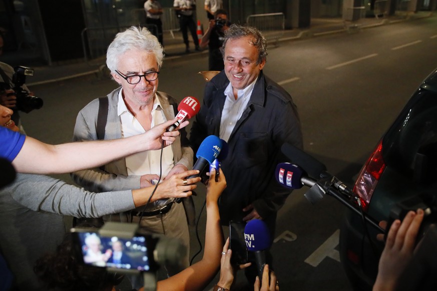 Michel Platini, right, and his lawyer William Bourdon answer reporters after Platini has been freed, outside the French police anti-corruption and financial crimes office in Nanterre, outside Paris, e ...