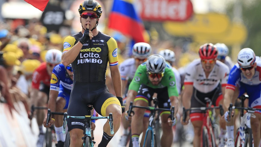 The flag of Slovakia flies as Netherlands&#039; Dylan Groenewegen, center, crosses the finish line ahead of Slovakia&#039;s Peter Sagan, wearing the best sprinter&#039;s green jersey, center, and Colo ...