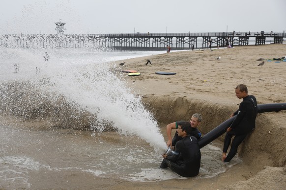 epaselect epa10811121 People play with a drainage hose on the beach in Seal Beach, California, USA, 20 August 2023. Southern California is under a tropical storm warning for the first time in history  ...