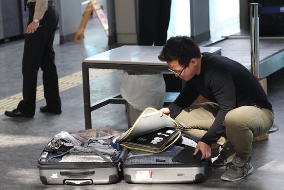 epa05862915 Passengers open their luggage and show their electronic equipment at security point at the Ataturk Airport, in Istanbul, Turkey, 2017. The United State and Britain have banned some electro ...