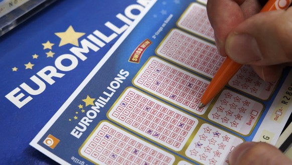 Un homme coche des numeros sur des bulletins de l' Euro Millions de la Loterie Romande dans le kiosque de Josephine, ce lundi 16 octobre 2023 a Cheseaux-sur-Lausanne pres de Lausanne. (KEYSTONE/S ...
