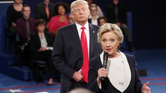 FILE - In this Oct. 9, 2016 file photo, Democratic presidential nominee Hillary Clinton, right, speaks as Republican presidential nominee Donald Trump listens during the second presidential debate at ...