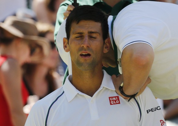 Novak Djokovic of Serbia is seen to by a trainer during his match against Richard Gasquet of France at the Wimbledon Tennis Championships in London, July 10, 2015. REUTERS/Suzanne Plunkett