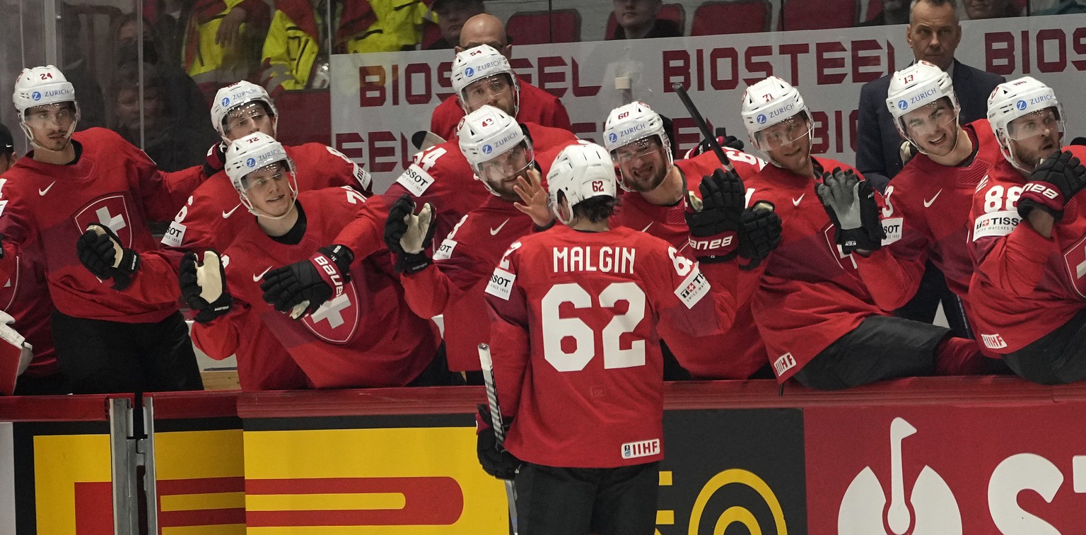 Denis Malgin of Switzerland, center, is celebrated after scoring during the group A Hockey World Championship match between Switzerland and Italy in Helsinki, Finland, Saturday May 14, 2022. (AP Photo ...