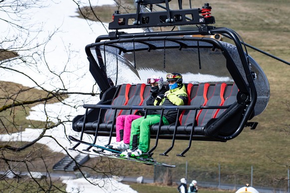 27.03.2021, Hessen, Willingen: Wintersportler mit Skiern sitzen am Ettelsberg im K1-Sessellift. Die Skisaison geht bis nach Ostern. (zu dpa: �Skigebiet Willingen bis nach Ostern ge�ffnet�) Foto: Swen  ...