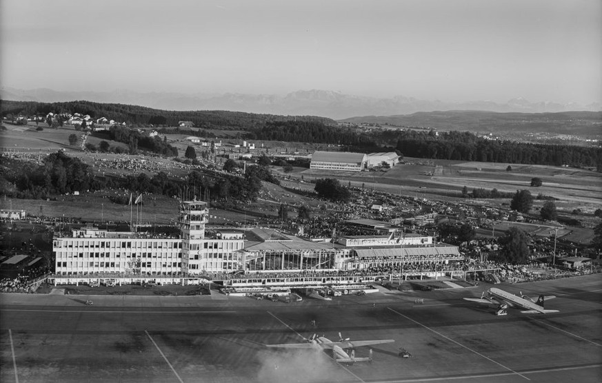 Flughof mit Vorfeld, im Vordergrund eine Airspeed AS.57 Ambassador der BEA, rechts die HB-IBE eine DC-6B der Swissair, Blick nach Südwesten (SW) zu den Hangars im Taubenried 30.08.1953