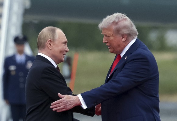 epa12303548 US President Donald Trump (R) welcomes Russian President Vladimir Putin during their meet to negotiate at Joint Base Elmendorf-Richardson in Anchorage, Alaska, USA, 15 August 2025. EPA/GAV ...
