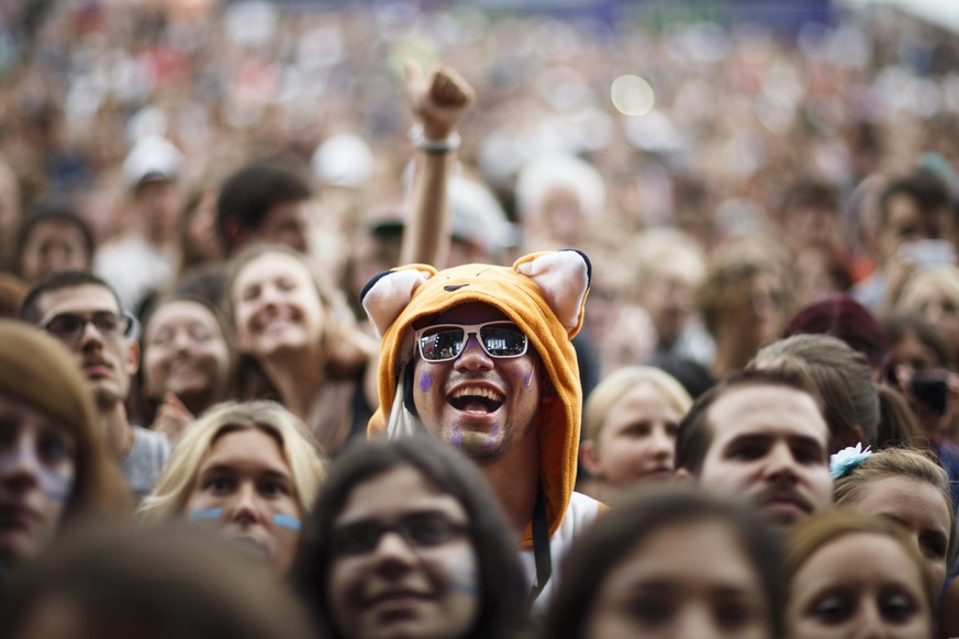 A festival goer wearing a costume cheers in the crowd as Swiss singer Bastian Baker performs on stage during the 39th edition of the Paleo Festival in Nyon, Switzerland, Tuesday, July 22, 2014. The Pa ...