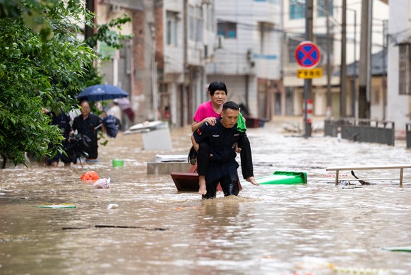 epa12196140 A rescuer helps evacuate a senior resident from a flood-affected area in Congjiang County, Guizhou Province, China, 24 June 2025. (issued 25 June 2025). Continuous heavy rainfall and upstr ...