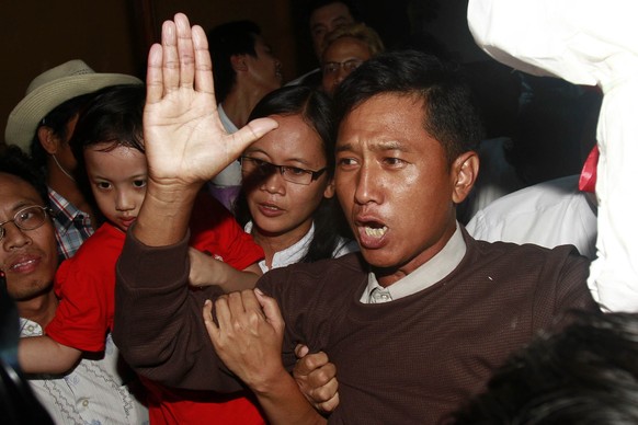FILE - Kyaw Min Yu, a pro-democracy activist talks to journalists as he arrives at Yangon airport welcomed by his wife Nilar Thein, background, also an activist and his daughter after being released f ...